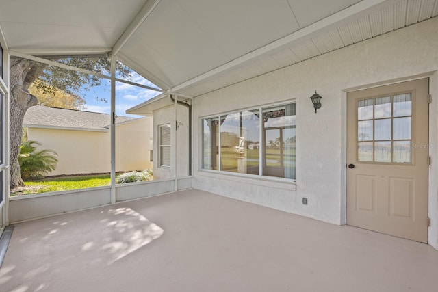 unfurnished sunroom with vaulted ceiling with beams