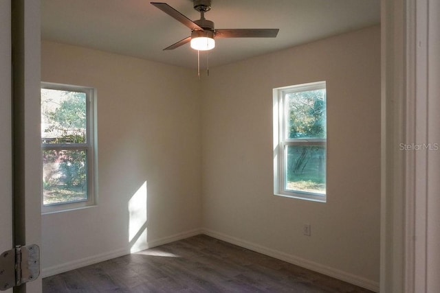 empty room with ceiling fan and dark hardwood / wood-style flooring