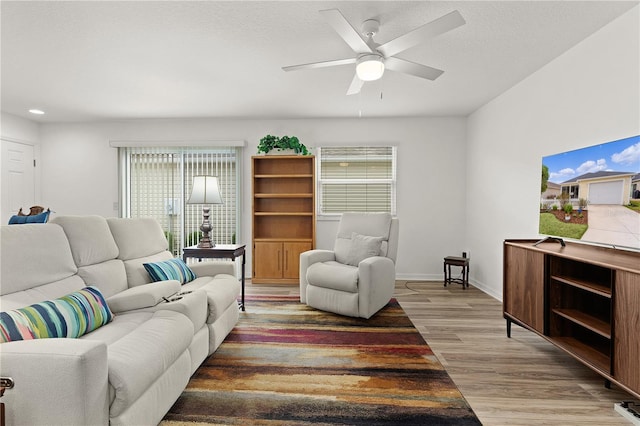 620 Vagabond St, The Villages, FL 32163 - living room with a textured ceiling, wood finished floors, a ceiling fan, and baseboards