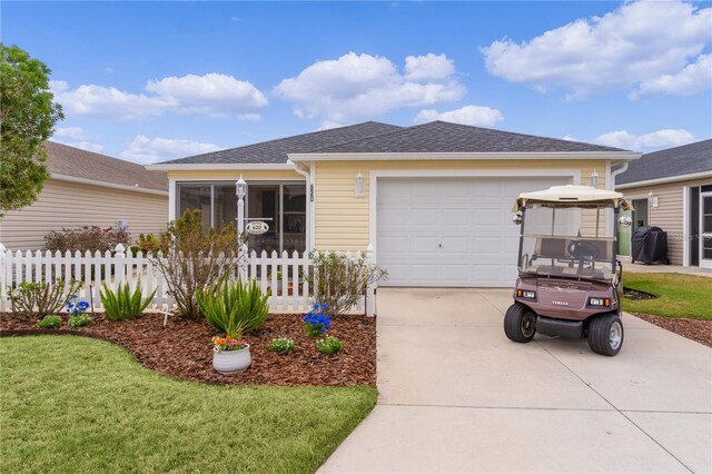 620 Vagabond St, The Villages, FL 32163 - view of front of property with concrete driveway, roof with shingles, an attached garage, fence, and a front yard