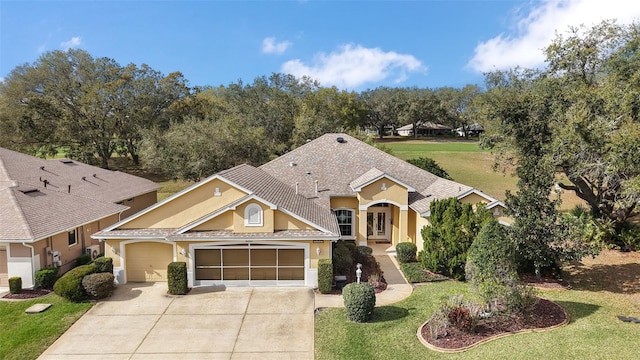 view of front of home featuring a garage, a front yard, concrete driveway, and stucco siding