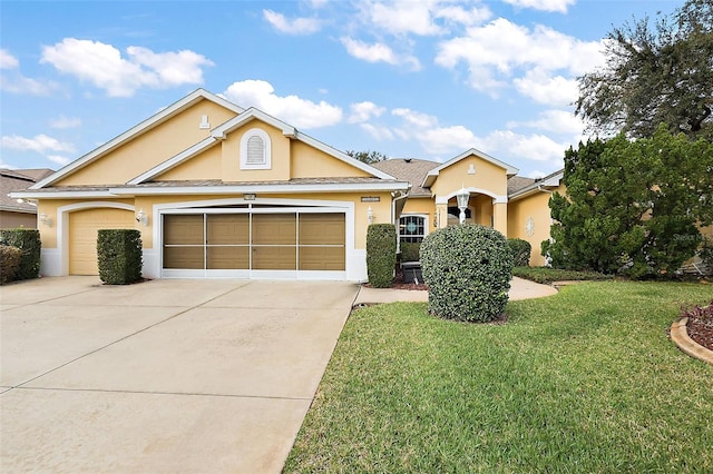 view of front of house featuring driveway, a front yard, an attached garage, and stucco siding