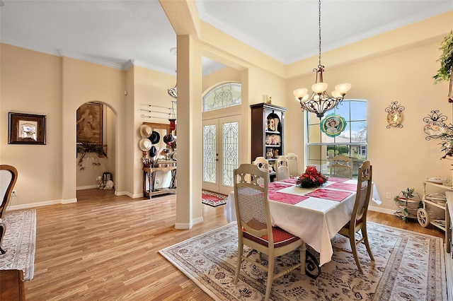 dining space featuring baseboards, french doors, light wood-style flooring, and crown molding