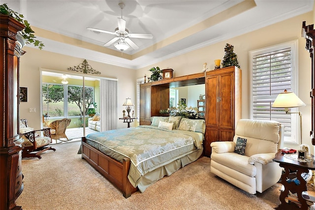 bedroom with access to exterior, a tray ceiling, light carpet, and crown molding