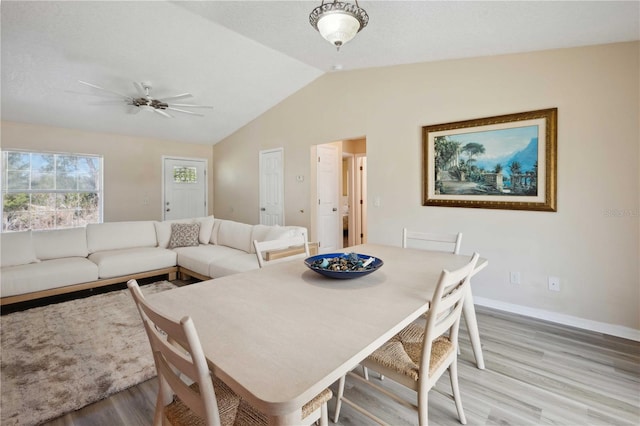 dining room with ceiling fan, light hardwood / wood-style flooring, and vaulted ceiling