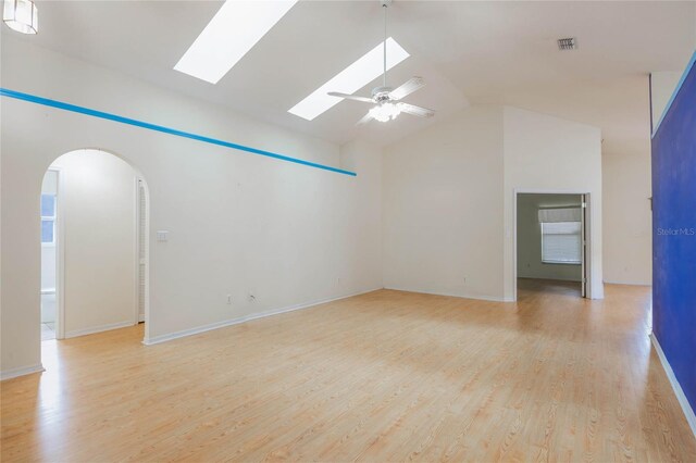 spare room with light wood-style floors, lofted ceiling, visible vents, and a ceiling fan