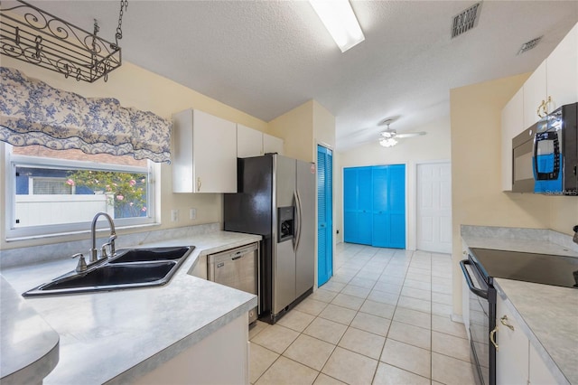 kitchen with lofted ceiling, a sink, visible vents, light countertops, and black appliances