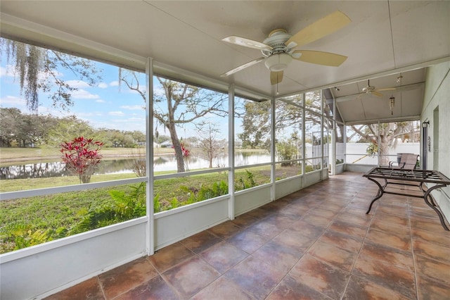 sunroom / solarium featuring a ceiling fan and a water view