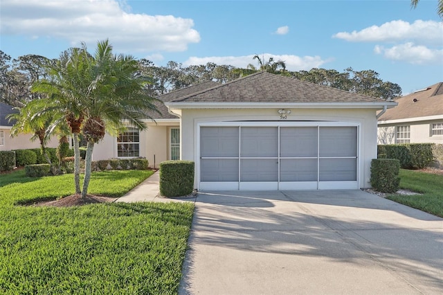 ranch-style home with a garage, concrete driveway, roof with shingles, a front lawn, and stucco siding