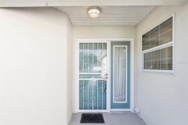 entrance to property featuring stucco siding