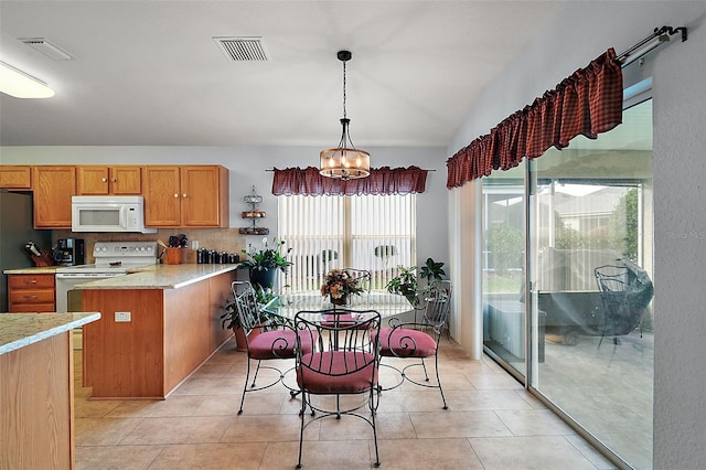 kitchen with a chandelier, light stone countertops, white appliances, brown cabinets, and pendant lighting