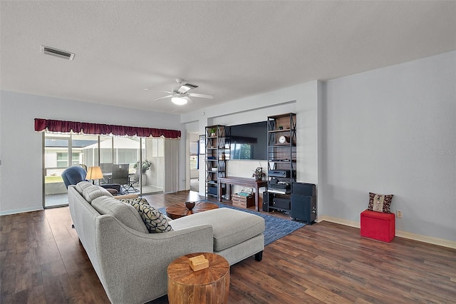 living area with a ceiling fan, a textured ceiling, visible vents, and dark wood-style flooring