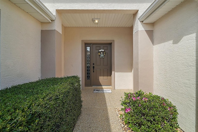 doorway to property featuring stucco siding