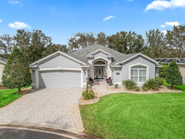 ranch-style home with decorative driveway, stucco siding, a shingled roof, a front yard, and a garage