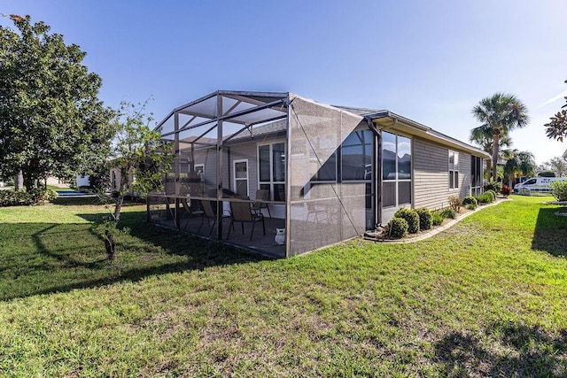 rear view of property featuring a yard, a lanai, and a patio area