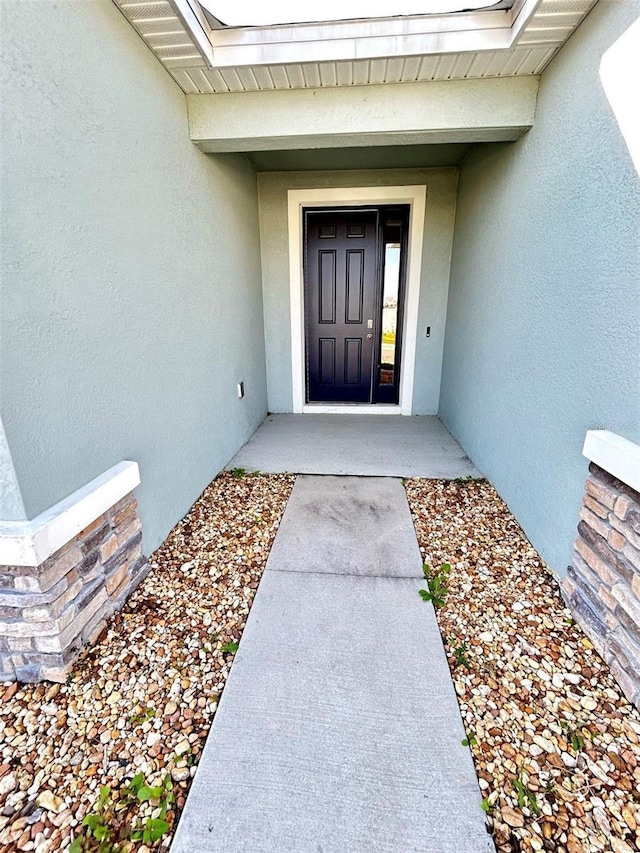 view of exterior entry featuring stucco siding