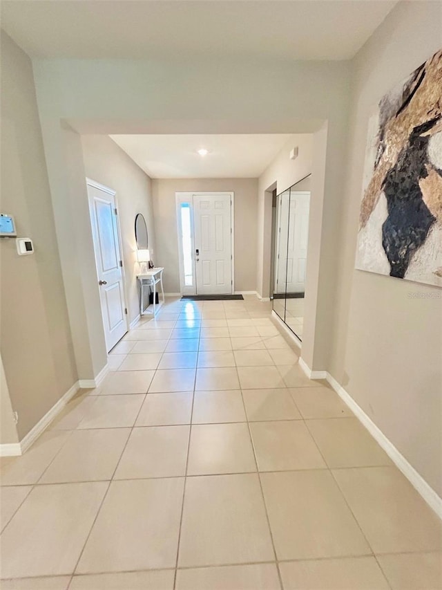 entryway with light tile patterned floors and baseboards