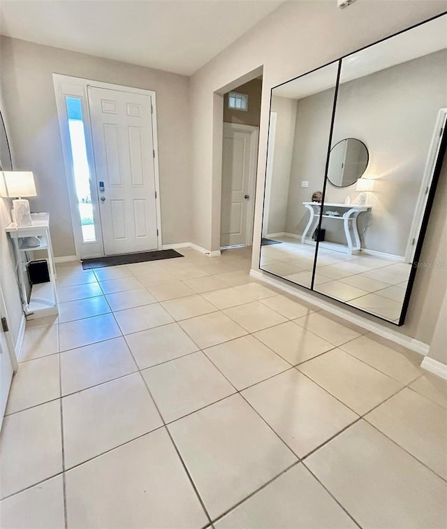 entrance foyer with light tile patterned flooring and baseboards