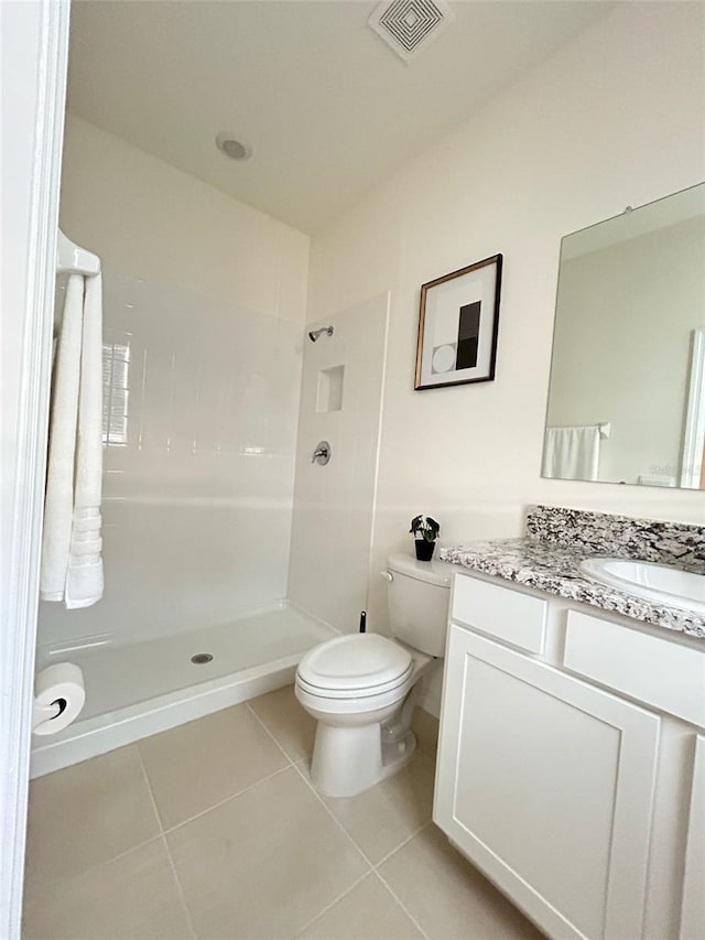 full bathroom featuring toilet, vanity, visible vents, tile patterned floors, and walk in shower