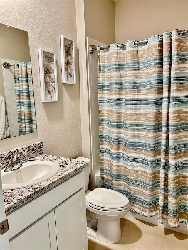 bathroom with a textured wall, tile patterned flooring, toilet, vanity, and shower / bathtub combination with curtain