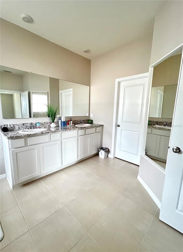 full bathroom featuring double vanity, lofted ceiling, a sink, and tile patterned floors