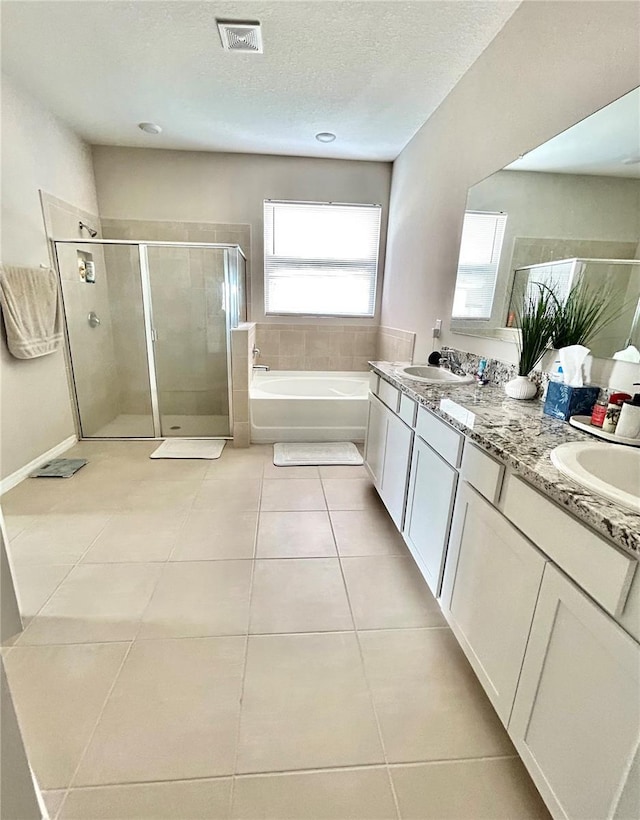 full bath with visible vents, a sink, a shower stall, tile patterned flooring, and a bath