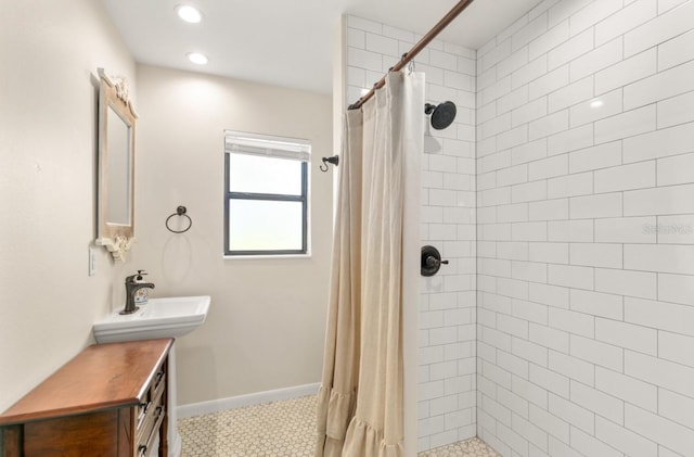 bathroom with a stall shower, recessed lighting, a sink, and baseboards