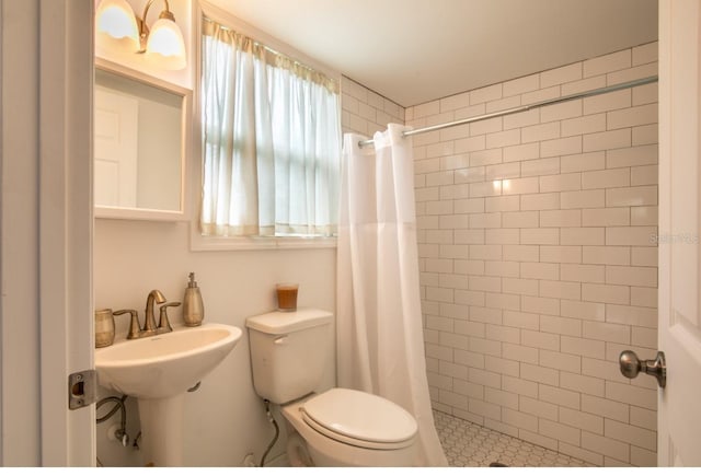 bathroom featuring a sink, a shower stall, and toilet