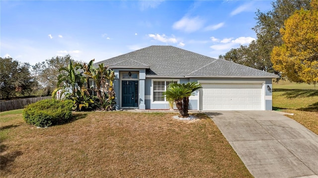 view of front of house with a garage, a front yard, concrete driveway, and fence