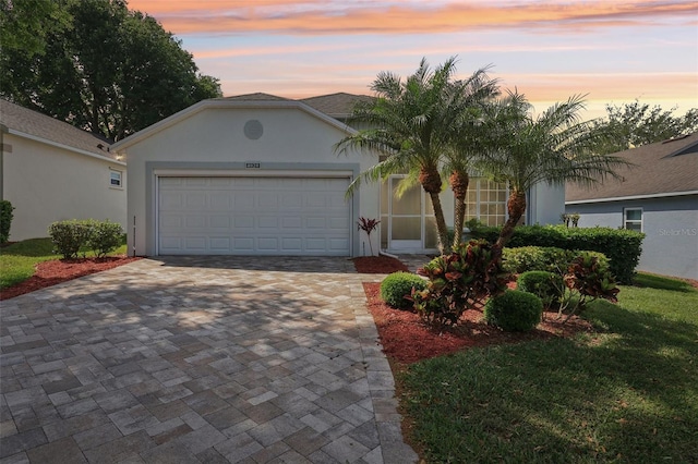 4020 Capland Ave, Clermont, FL 34711 - ranch-style home with stucco siding, an attached garage, and decorative driveway