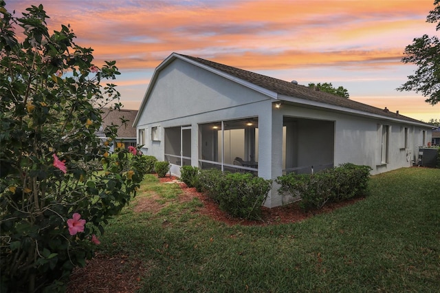 4020 Capland Ave, Clermont, FL 34711 - property exterior at dusk with stucco siding, a yard, and a sunroom