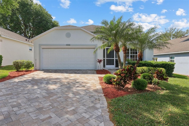 4020 Capland Ave, Clermont, FL 34711 - view of front of property featuring stucco siding, decorative driveway, a garage, and a front lawn