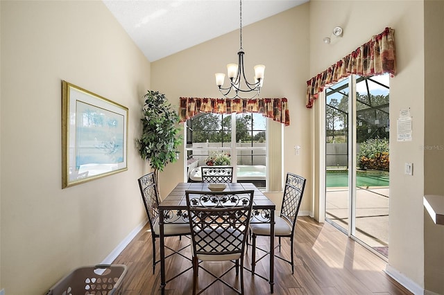 dining room featuring a chandelier, wood finished floors, lofted ceiling, and a healthy amount of sunlight