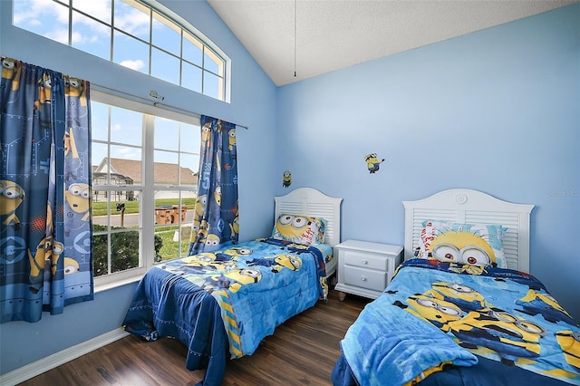 bedroom with dark wood-style floors, vaulted ceiling, a textured ceiling, and baseboards