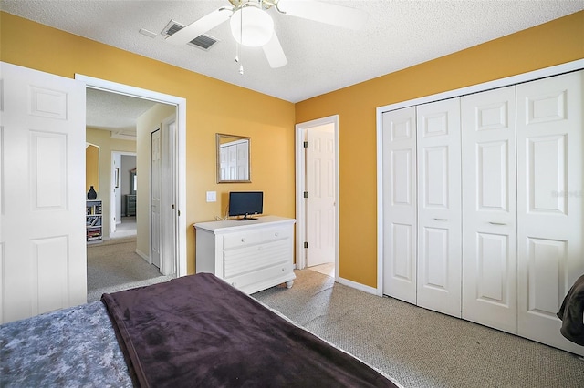 bedroom featuring ceiling fan, a closet, visible vents, and a textured ceiling