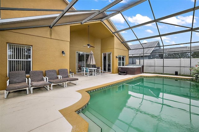 view of pool featuring a hot tub, a ceiling fan, a patio area, fence, and a lanai