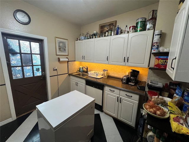 kitchen with dishwasher, tasteful backsplash, a sink, and white cabinets