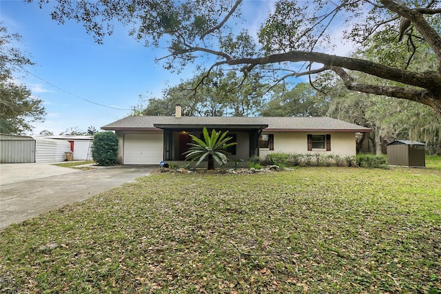 view of front facade with concrete driveway, a chimney, an attached garage, a front lawn, and stucco siding