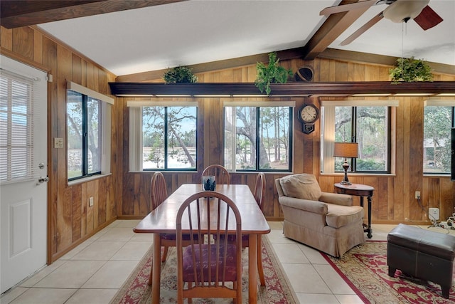 dining area featuring light tile patterned flooring, vaulted ceiling with beams, and wooden walls