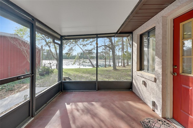 unfurnished sunroom with plenty of natural light and a water view