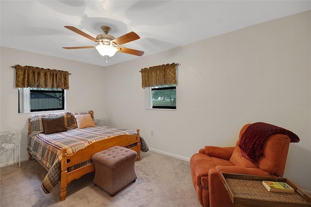 bedroom with light colored carpet, ceiling fan, and baseboards