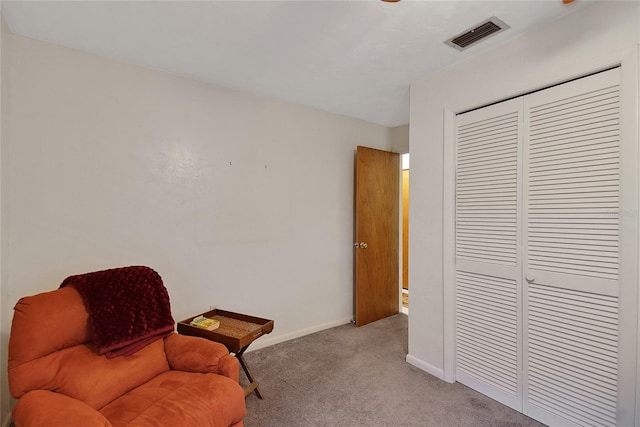 living area featuring baseboards, visible vents, and light colored carpet