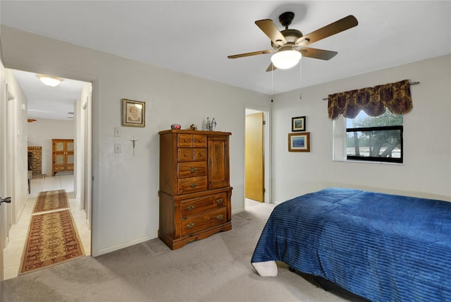 bedroom with a ceiling fan, light colored carpet, and baseboards