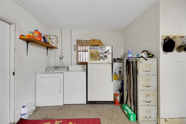 washroom with washer and dryer, laundry area, and concrete block wall