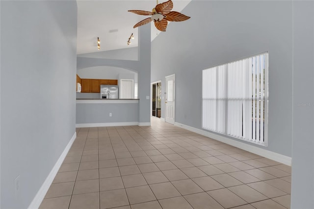 unfurnished living room with ceiling fan, light tile patterned floors, and baseboards