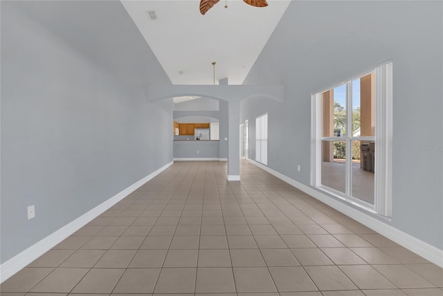 unfurnished living room featuring light tile patterned floors, ceiling fan, and baseboards