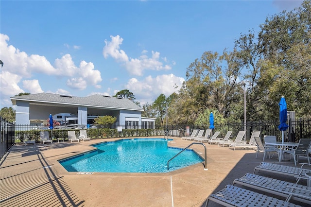 community pool with fence and a patio