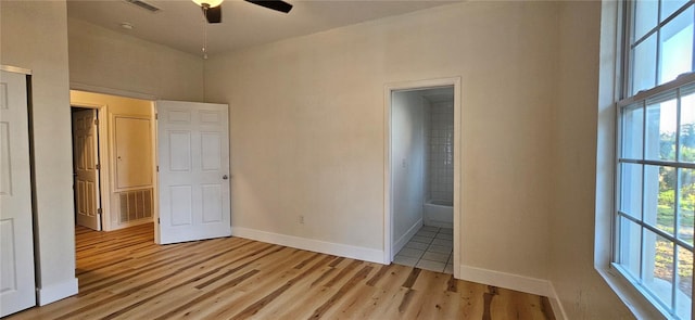 unfurnished bedroom featuring light wood-type flooring, multiple windows, visible vents, and baseboards