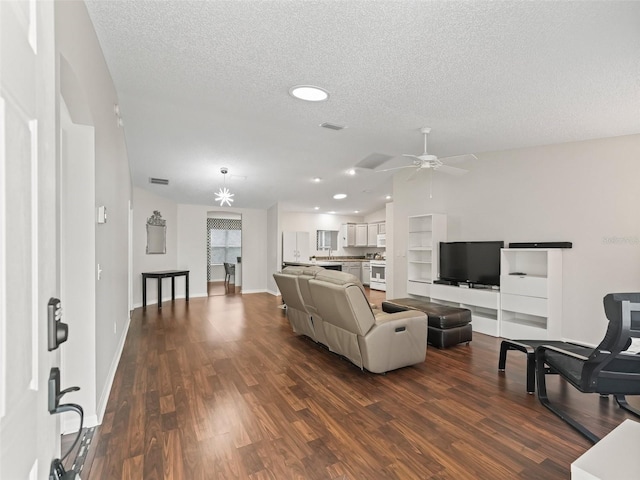 living area with a textured ceiling, baseboards, vaulted ceiling, and dark wood-style flooring