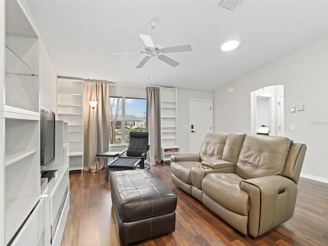 living area featuring dark wood-style flooring, visible vents, a ceiling fan, a textured ceiling, and baseboards